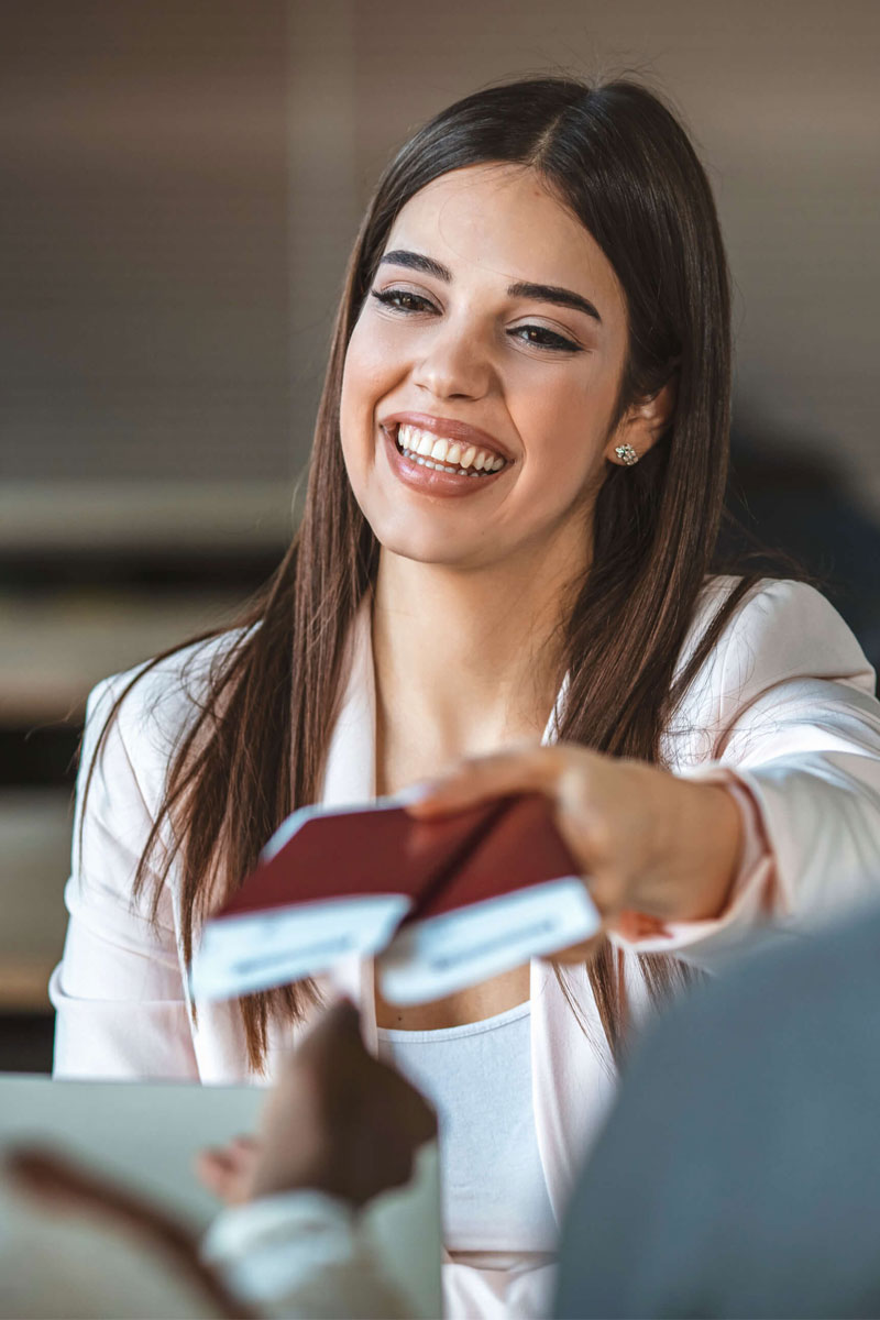 A U.S. government worker presenting an immigrant and spouse receiving their O-1, L-1, or H-1B visa and passport.